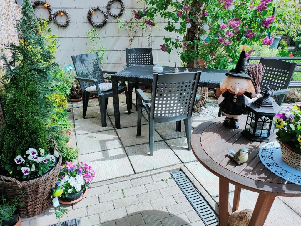 eine Terrasse mit einem Tisch, Stühlen und Blumen in der Unterkunft Ferienhaus Alte Tante in Thale