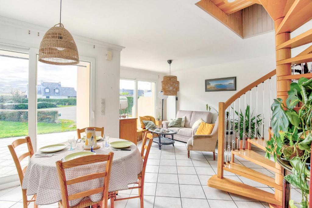 ein Esszimmer mit einem Tisch und ein Wohnzimmer in der Unterkunft Louisette - Vue mer à moins de 1km de la plage in Erquy