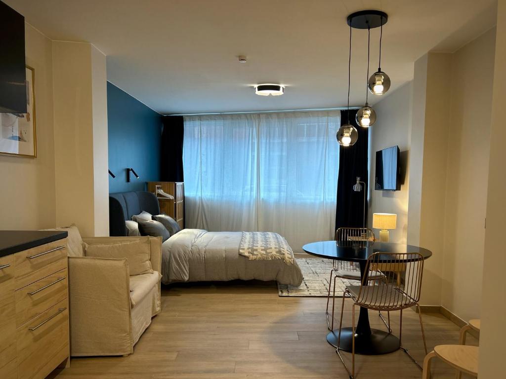 Suite luxueuse aux Guillemins في لييج: غرفة نوم بسرير وطاولة في غرفة