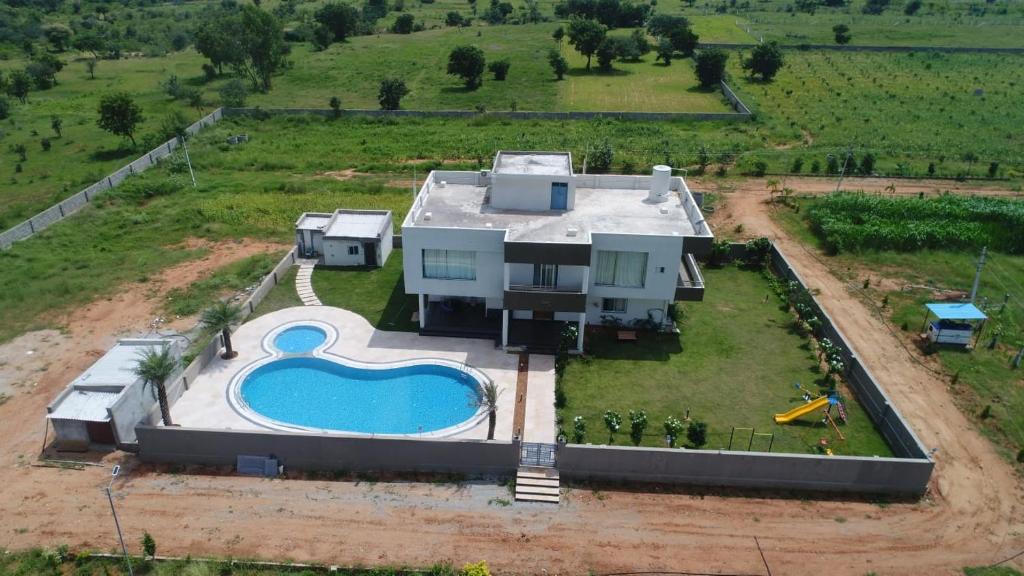 eine Luftansicht eines Hauses mit Pool in der Unterkunft Jha Farm & resorts 