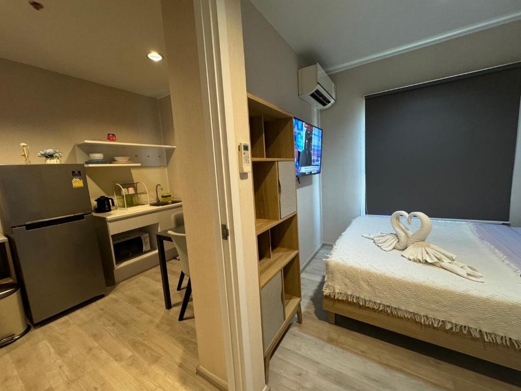 um pequeno quarto com uma cama e uma cozinha em Plum central westgate@Bangyai em Ban Bang Krabu