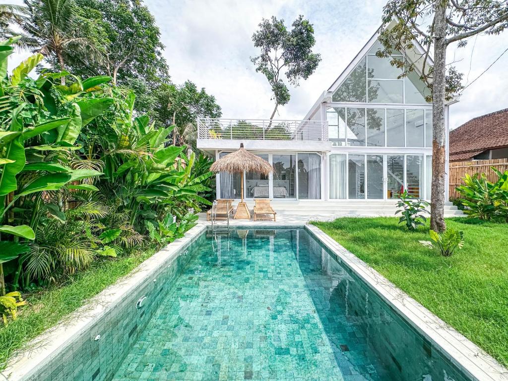 a swimming pool in front of a house at White Villa Ubud in Ubud