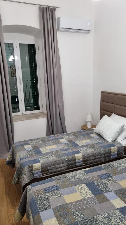 a bedroom with a bed with a quilt on it at Main Square View in Kotor