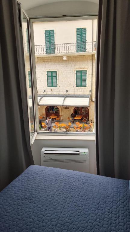 a bedroom with a window looking out at a building at Main Square View in Kotor