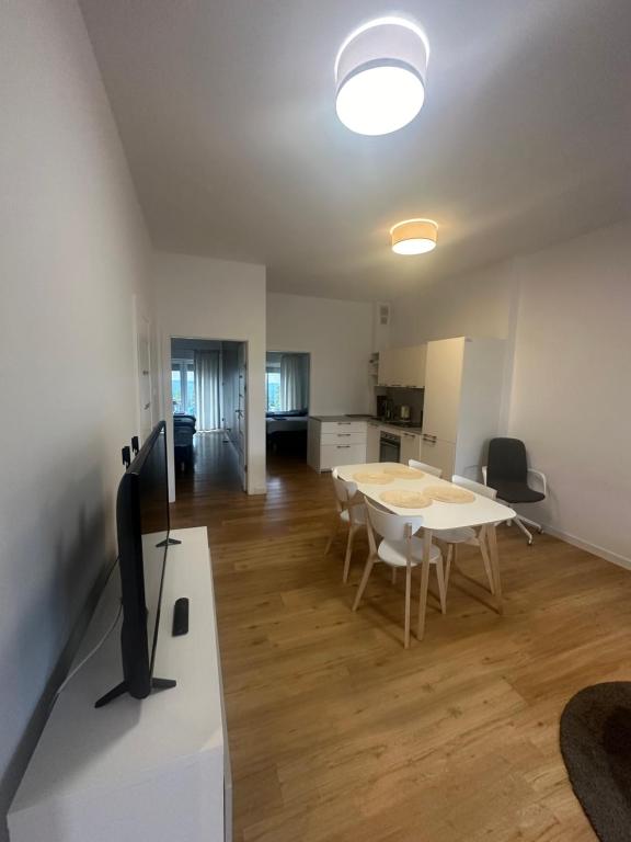 sala de estar con mesa y TV. en Nowoczesne mieszkanie 65 m2, en Chojnice