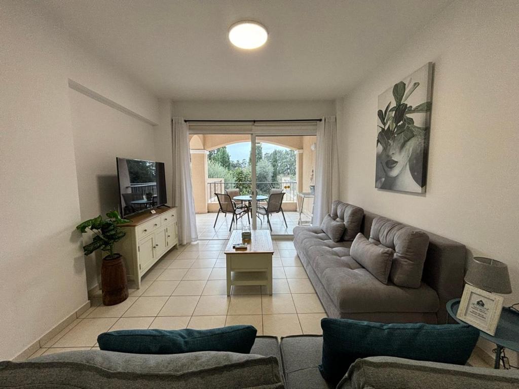 sala de estar con sofá y TV en Cozy Apartment in Paphos Beautiful Complex, en Pafos
