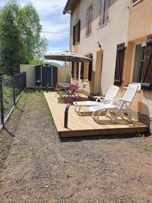 un groupe de chaises et un parasol sur une terrasse en bois dans l'établissement Rez de jardin 6 pers. Gérardmer, à Gérardmer
