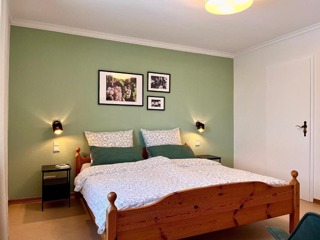 a bedroom with a bed with green walls at Pension 1595 im Weingut Botzet in Maring-Noviand