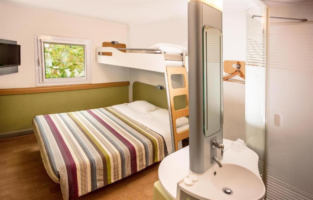 ヨハネスブルグにあるSUN1 O.R.TAMBOの小さな客室で、二段ベッド1組、シンクが備わります。