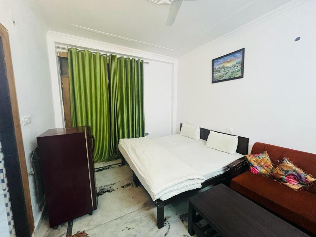 Hotel Apollo - Near Apollo Hospital في نيودلهي: غرفة بسرير وستارة خضراء
