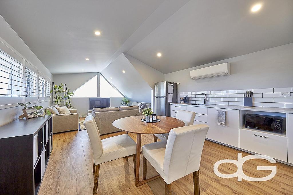 a kitchen and living room with a table and chairs at Federal Apartments South Fremantle in South Fremantle