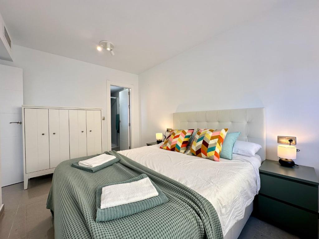 Un dormitorio blanco con una cama grande y una mesa en Zarauz sea views. Águilas Costa Cálida., en Águilas