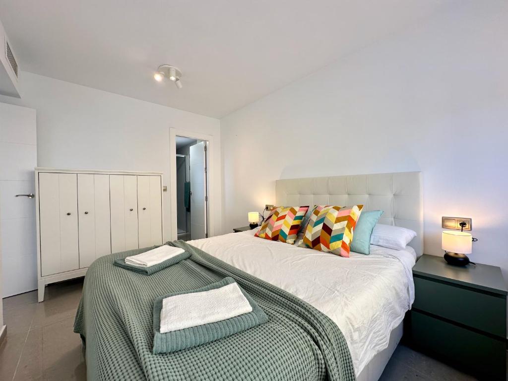 a white bedroom with a large bed and a table at Zarauz sea views. Águilas Costa Cálida. in Águilas