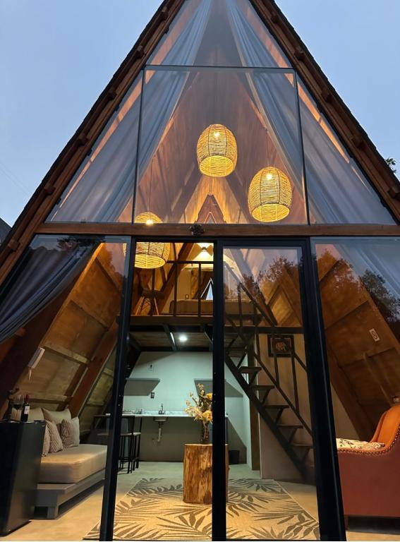 a glass walled in living room of a tree house at NIDU Cabañas Boutique & Holística in Mineral del Monte