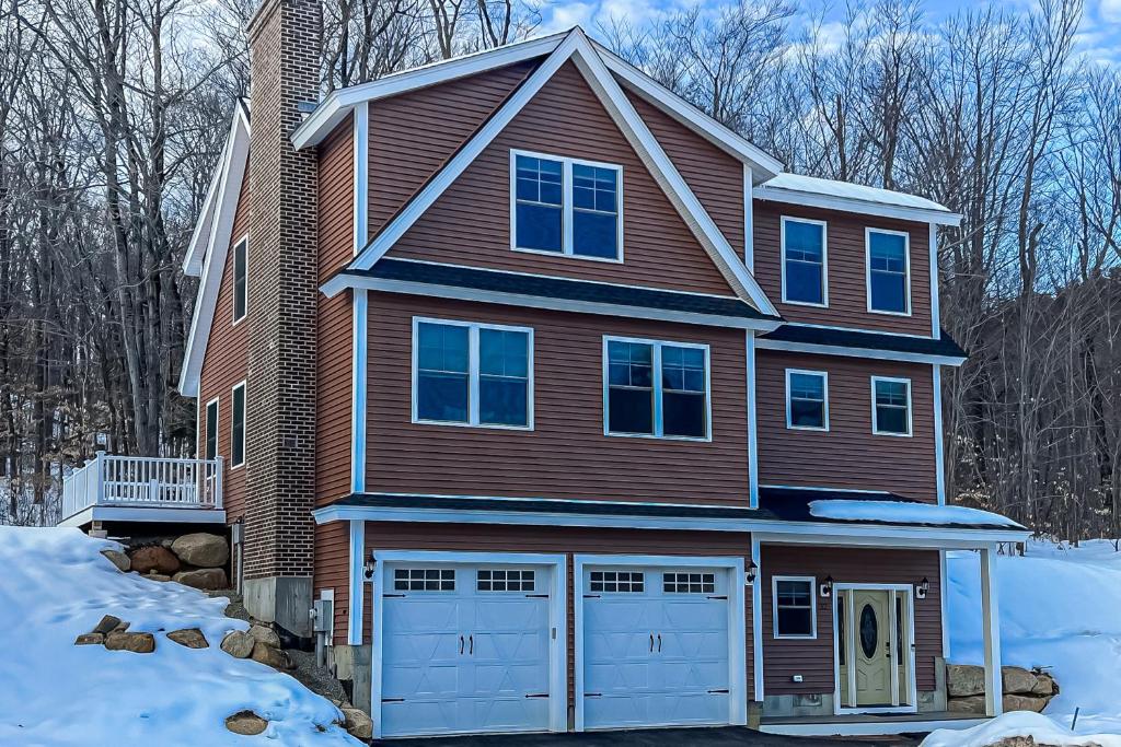a house with two garage doors in the snow at Beechwoods Mountain Living in Intervale