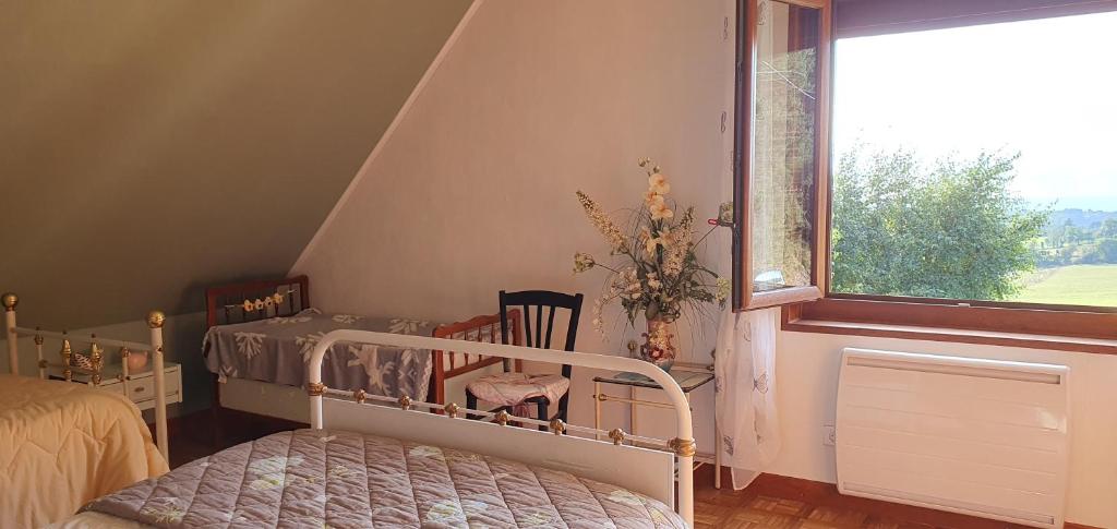 a bedroom with a bed and a window at Horizon Aubrac Laguiole in Laguiole
