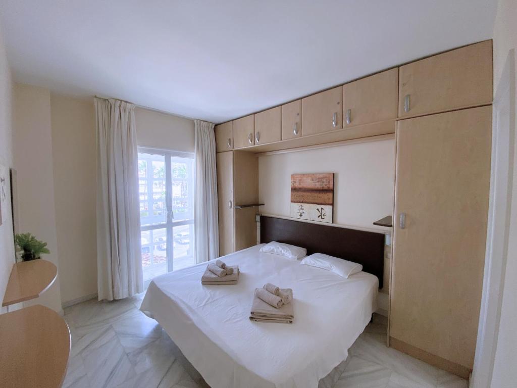 A bed or beds in a room at Benalmadena Harbour Penthouse with big terrace and sea view