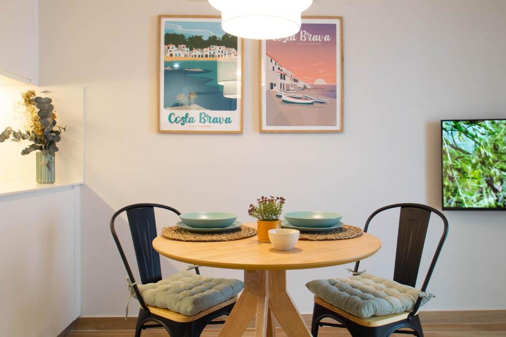 mesa de comedor con 2 tazones y sillas en Budget Beach Studio 23 en Sant Antoni de Calonge