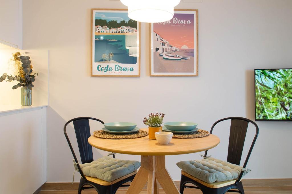 a dining room table with two bowls and chairs at Budget Beach Studio 23 in Sant Antoni de Calonge