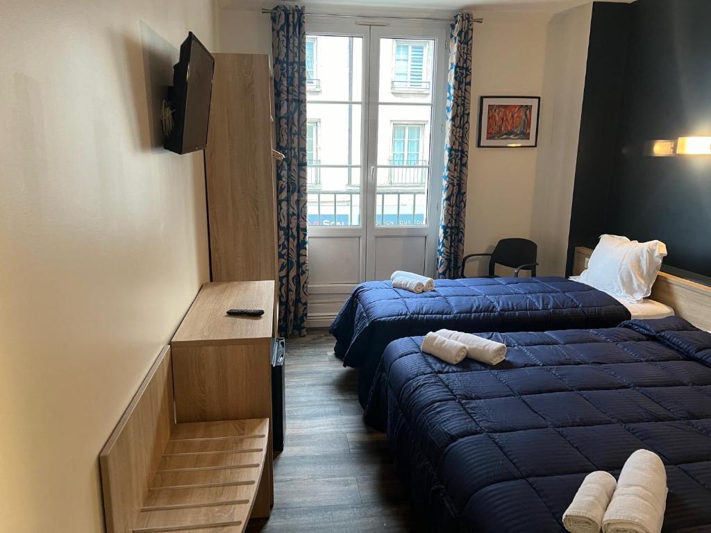 um quarto de hotel com duas camas e uma janela em Armor Hotel em Compiègne