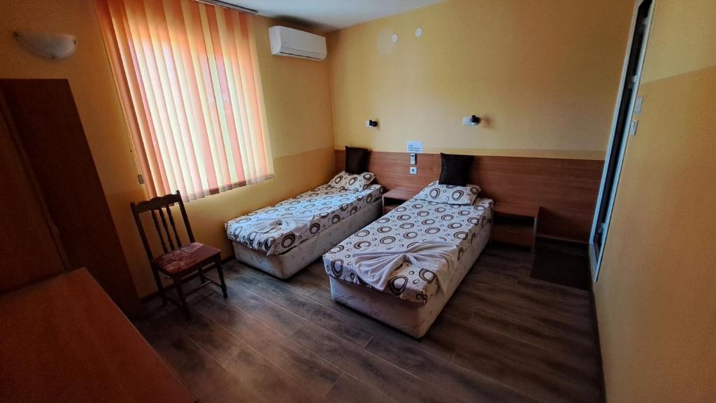 Habitación con 2 camas y silla en Hotel Toni en Bukovlŭk
