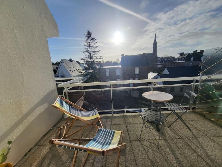 uma varanda com 2 cadeiras e uma mesa na varanda em Studio "La Parenthèse", à 50 mètres de la plage em Saint-Quay-Portrieux