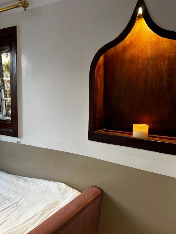 a bedroom with a bed and a window with a candle at Houseboat Hotel and Nile Cruises Zainoba in Nag` el-Ramla