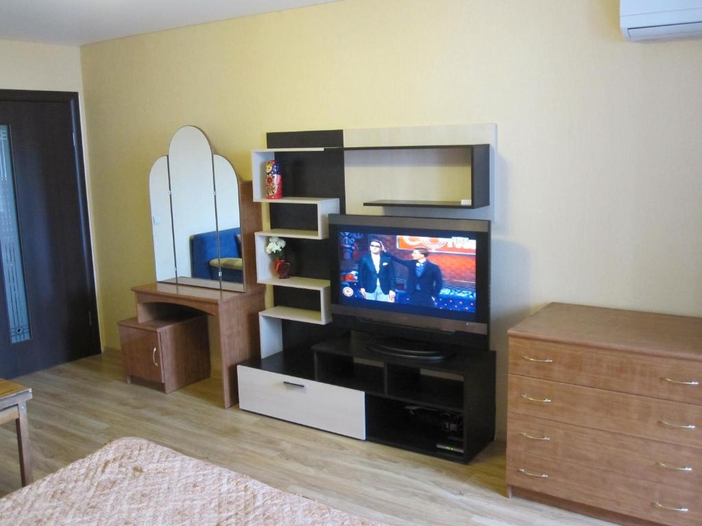 ein Wohnzimmer mit einem TV in einem Entertainment-Center in der Unterkunft Apartment Na Antonova-Ovseenko in Woronesch