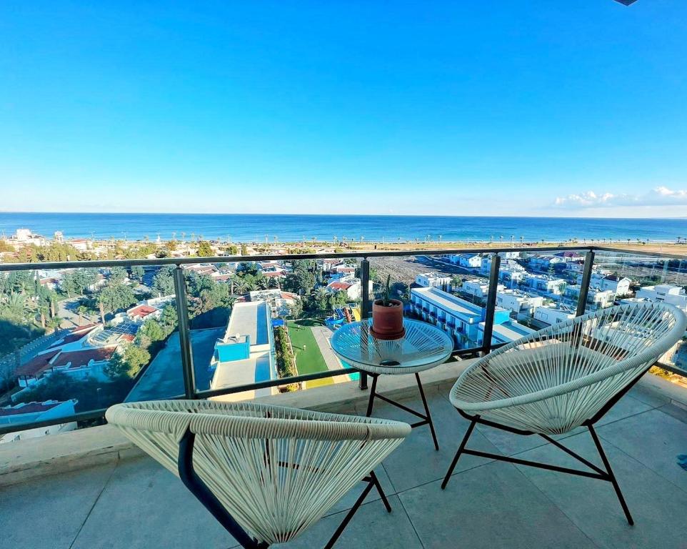 a balcony with two chairs and a table and the ocean at Amazing seaview studio with pool-steps away beach in Áyios Yeórgios