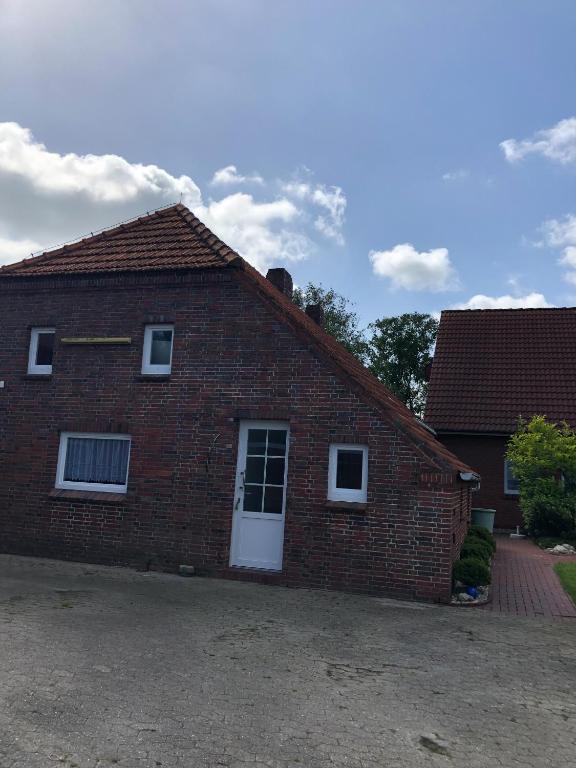 a red brick house with a white door at Ferienwohnung Nordmoor in Blomberg