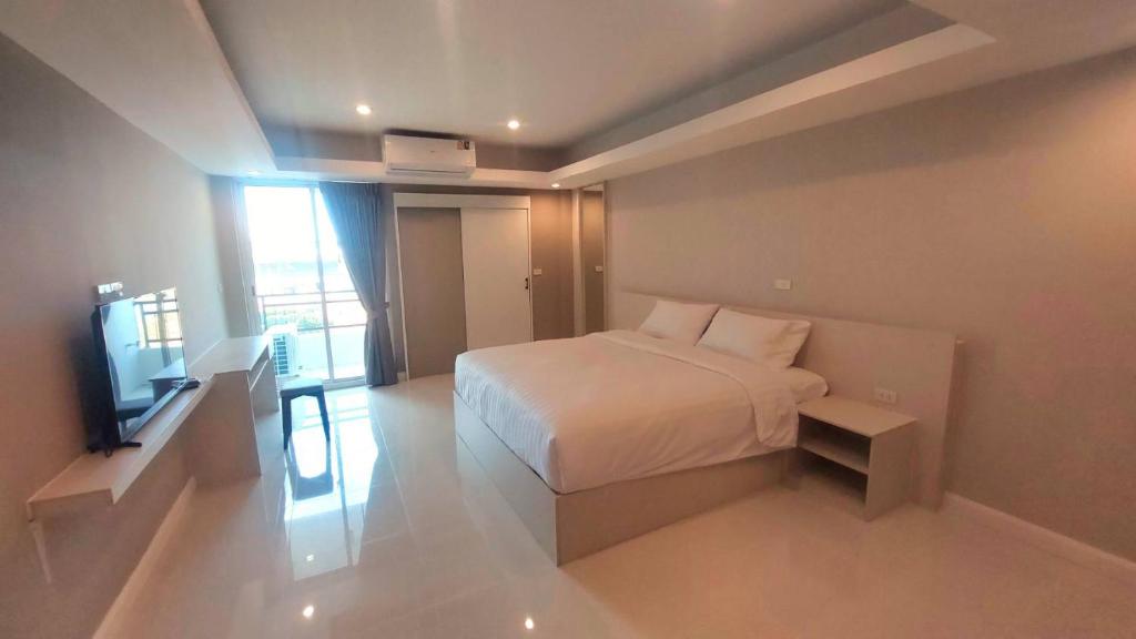 a bedroom with a bed and a television in it at PKK hotel Residence in Bang Phli