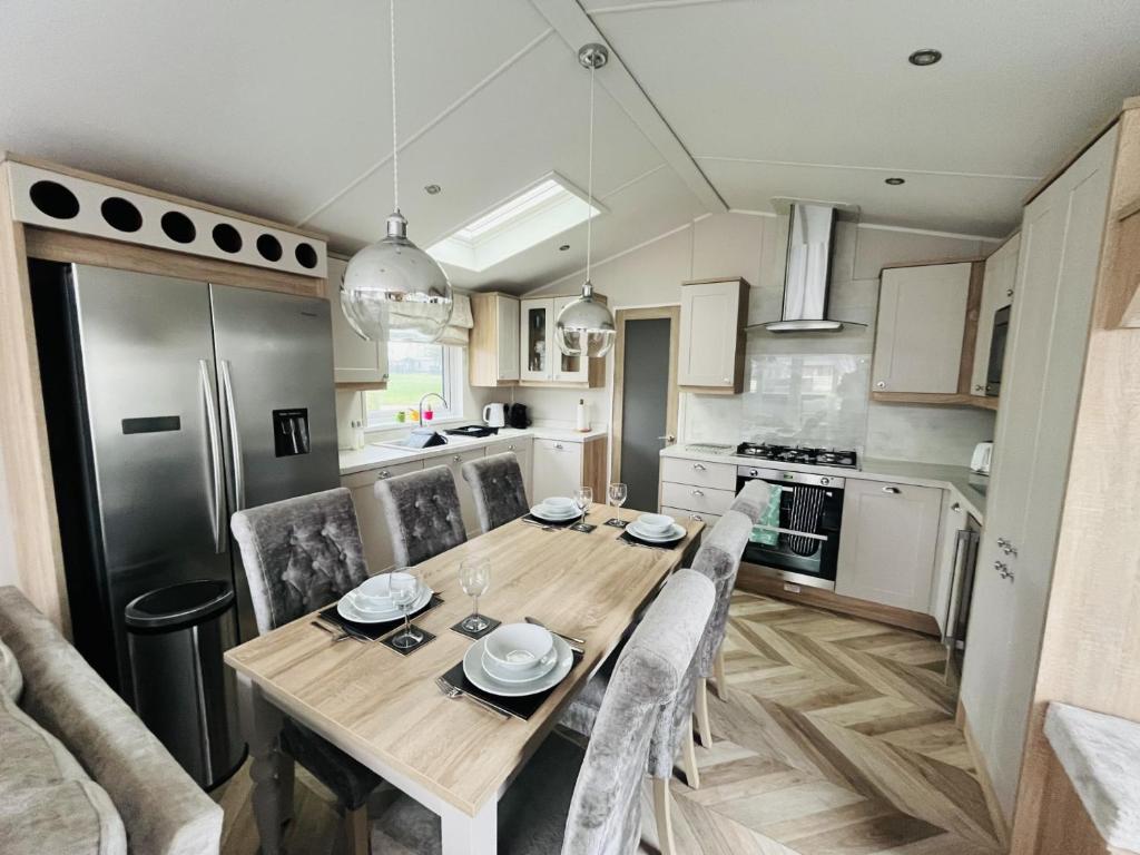 a kitchen and dining room with a wooden table and chairs at White Swan Lodge in Allerthorpe