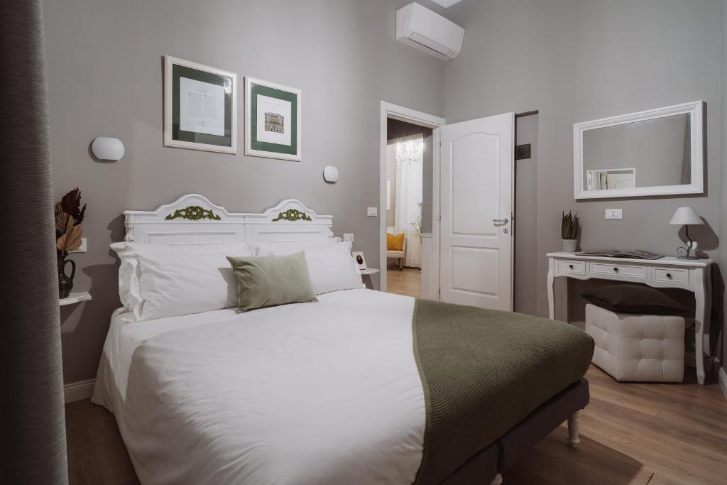 een slaapkamer met een groot wit bed en een open haard bij Rooms Genova dei Rolli in Genua