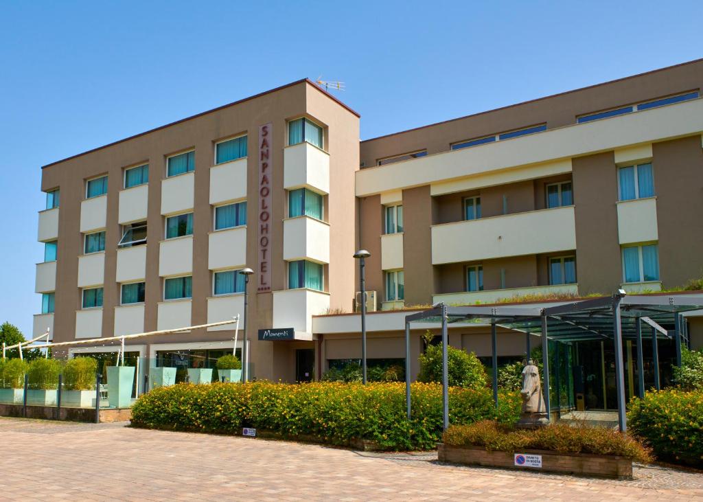 a hotel building with a statue in front of it at San Paolo Hotel in Montegiorgio