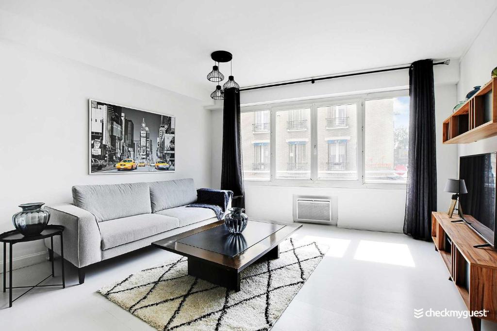 ein Wohnzimmer mit einem Sofa und einem Couchtisch in der Unterkunft Amazing apartment 3BR Convention in Paris