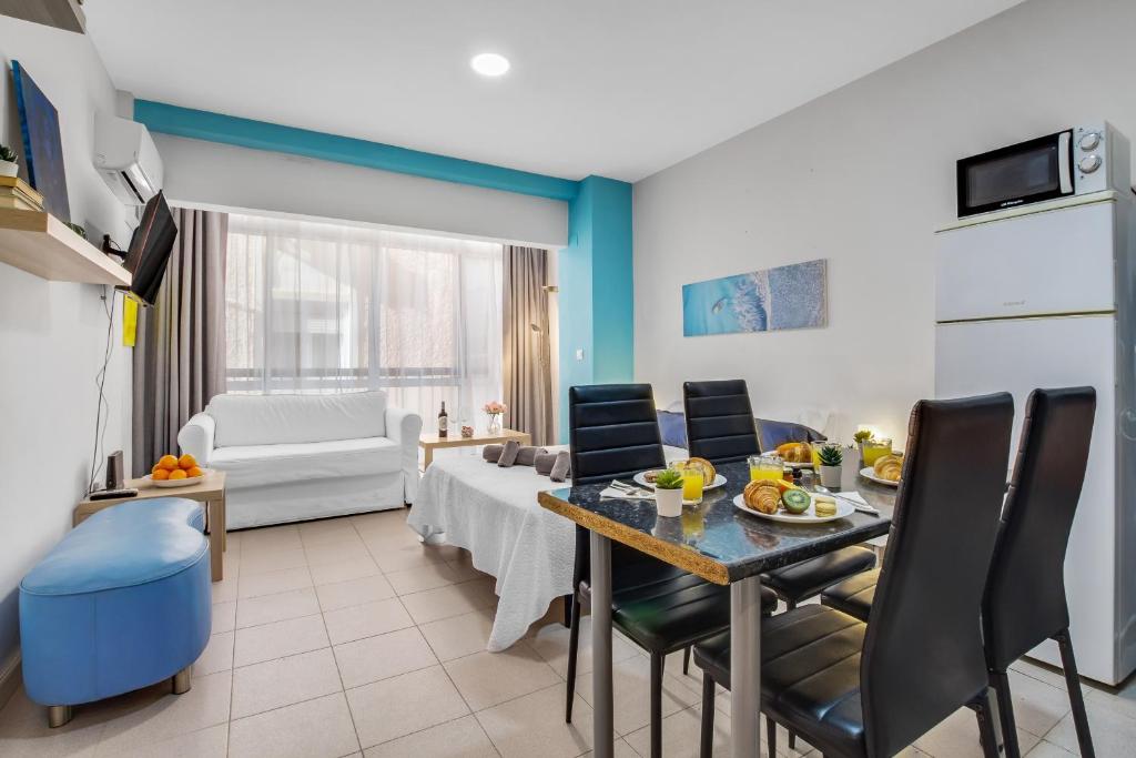 a kitchen and living room with a table and chairs at Castellano de SteraM Flats Torremolinos in Torremolinos
