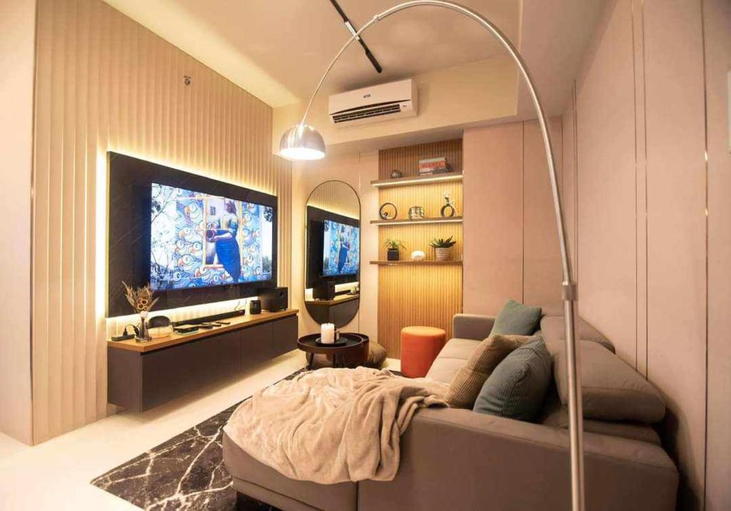 sala de estar con sofá y TV de pantalla plana en The house of us, en Manila