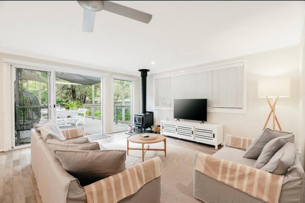 a living room with two couches and a television at Loulu in Pearl Beach