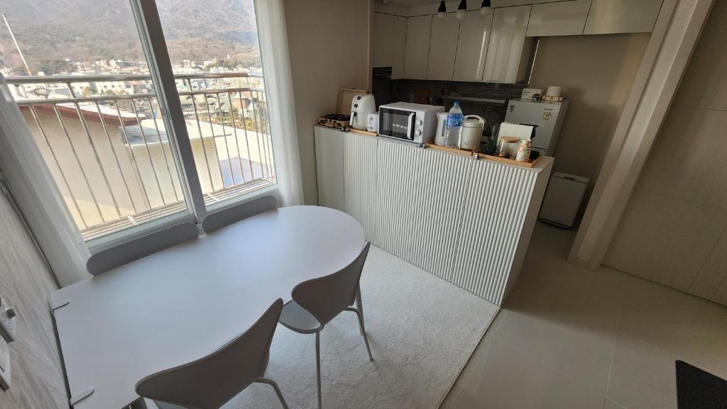 lI - Full option two-room mountain view private house في سول: طاولة بيضاء وكراسي في غرفة مع نافذة