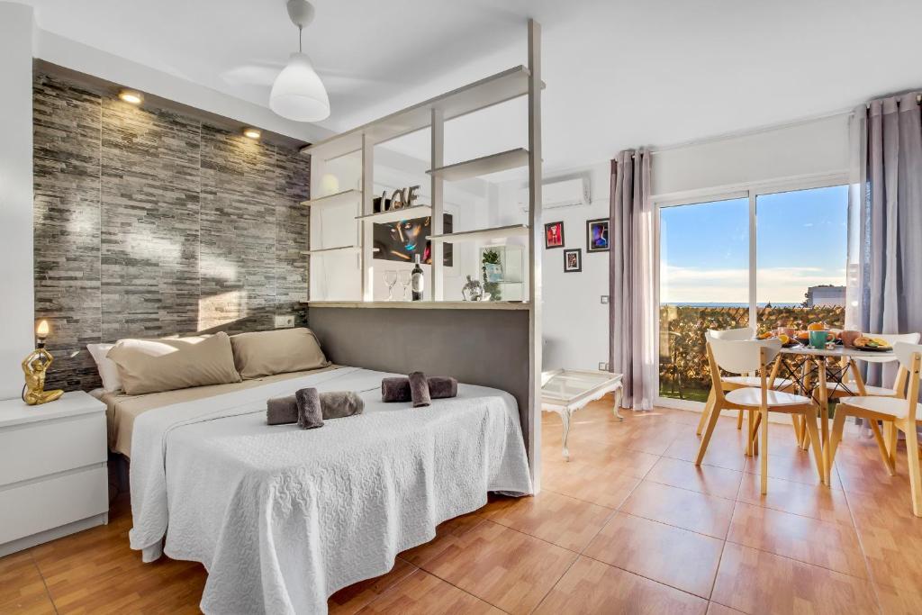 1 dormitorio con 1 cama grande y comedor en Salome de SteraM Flats Torremolinos, en Torremolinos