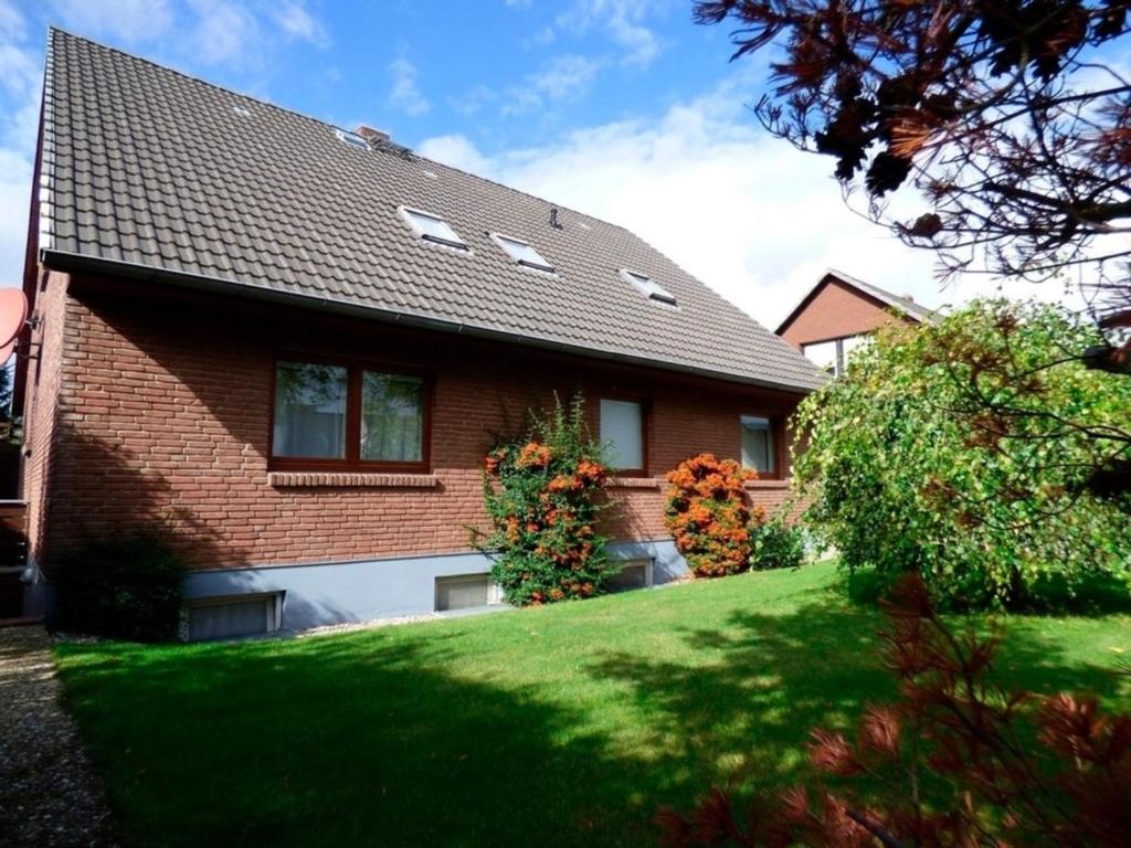 una casa de ladrillo marrón con césped verde en Sommerweg Wohnung II 9247II, en Fehmarn