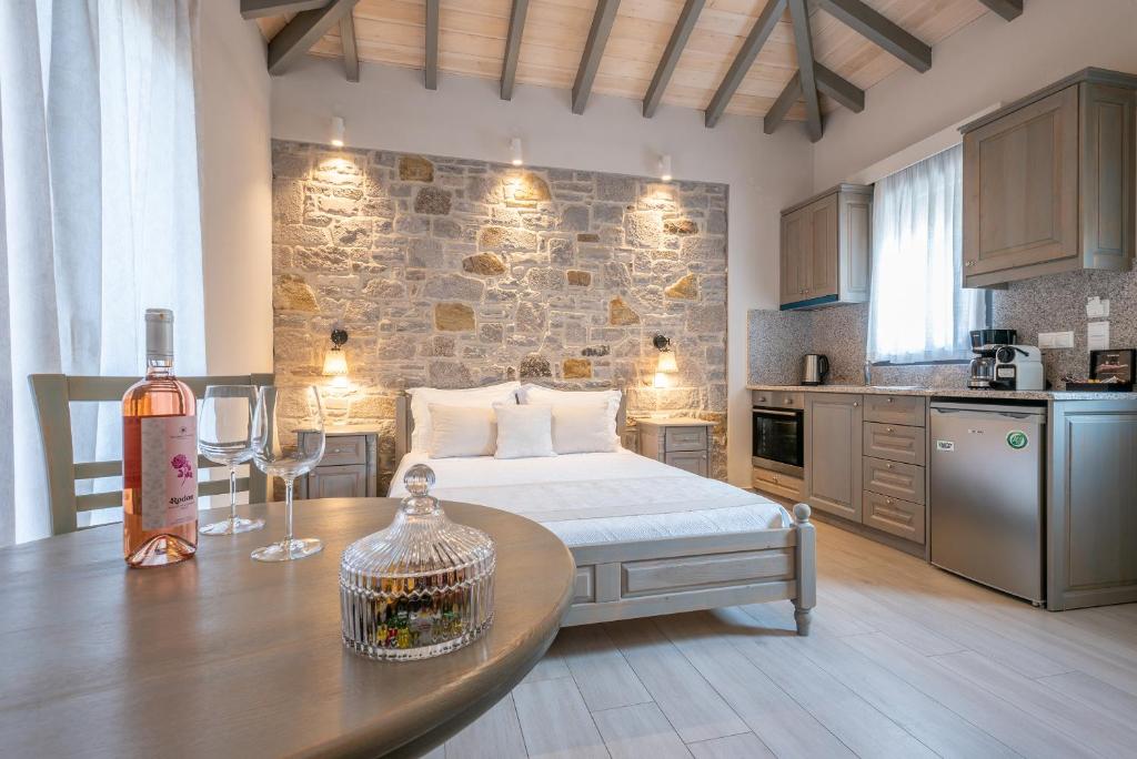 una camera con letto e tavolo con una bottiglia di vino di AMYGDALIES STONE APARTMENTS a Mirina