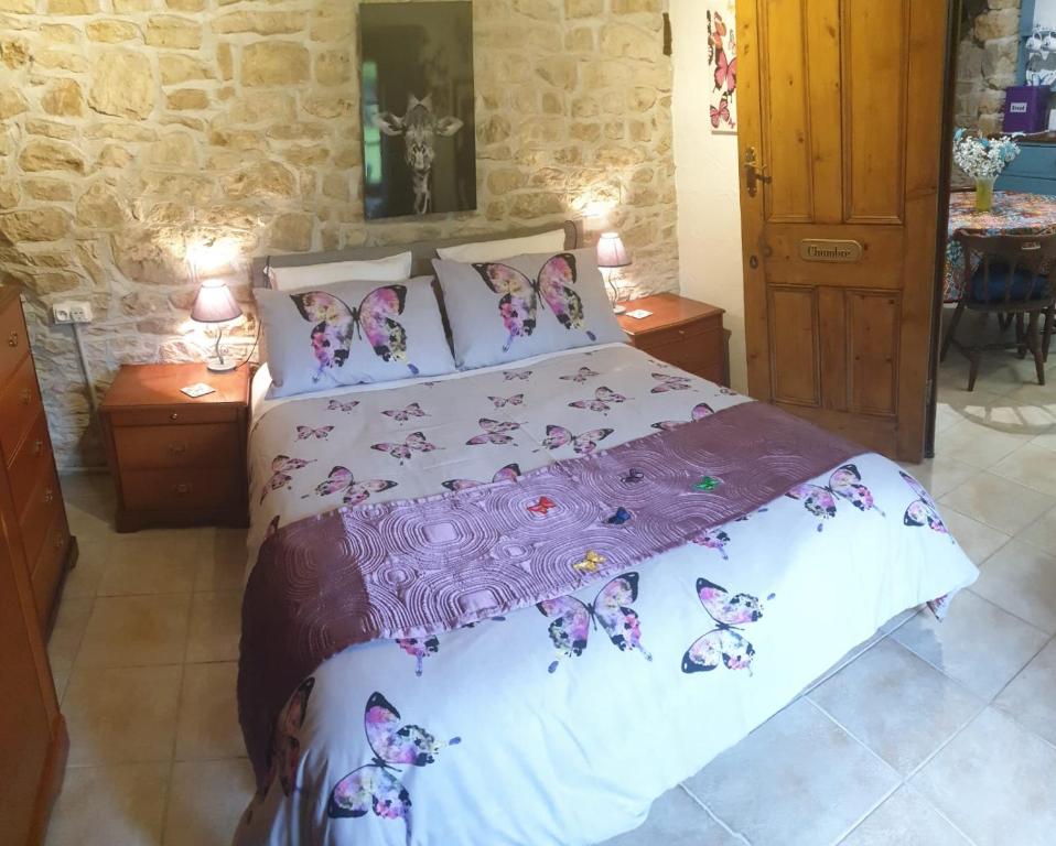 a bedroom with a bed with butterflies on it at Chocolate Box Cottage in Parzac