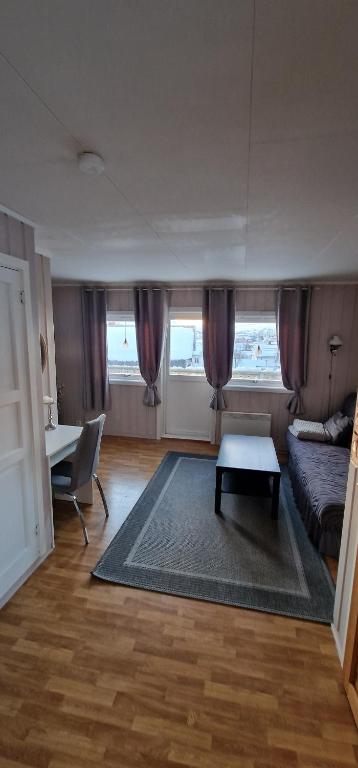 uma sala de estar com uma cama e uma mesa em Nordskogveien 12b em Båtsfjord