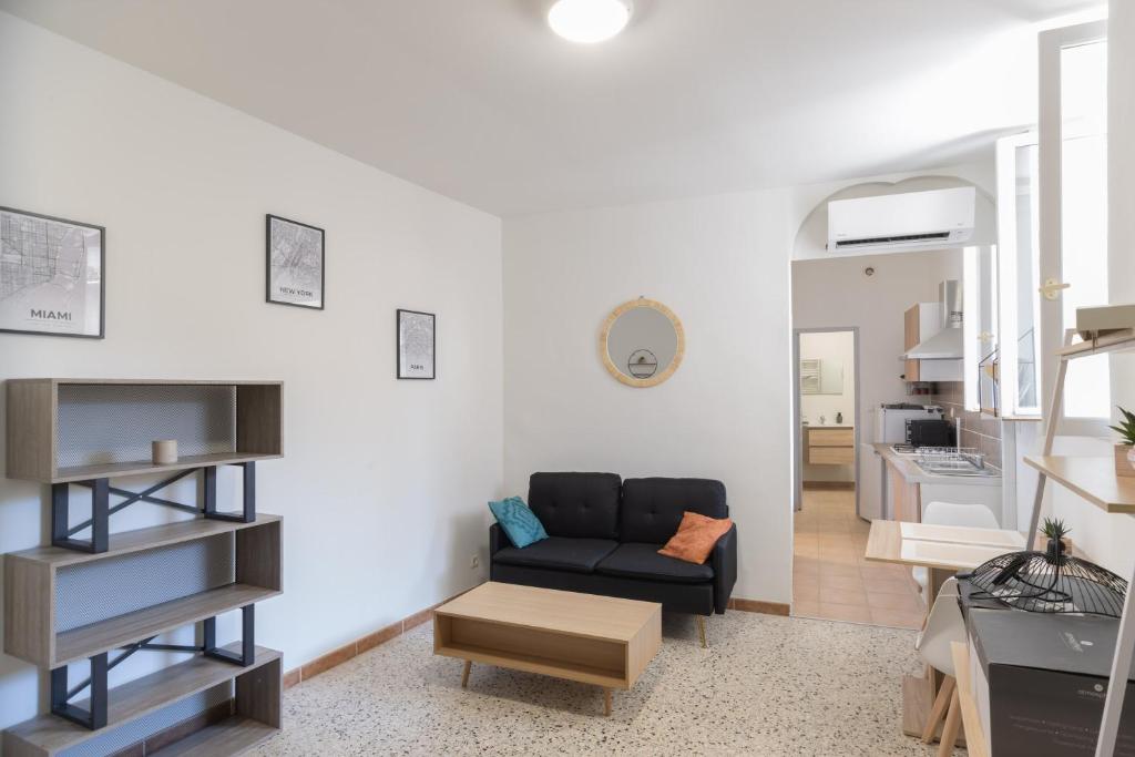 a living room with a couch and a table at Le Fou - Appt dans le centre dAubenas in Aubenas