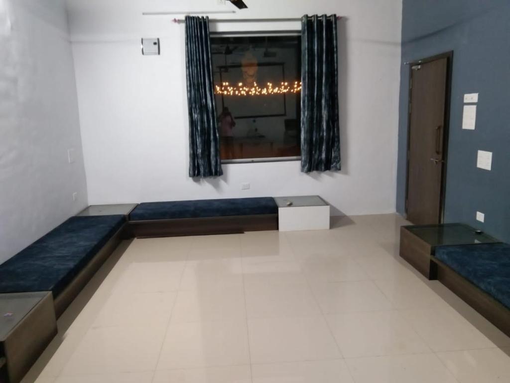 浦那的住宿－Jadhav Farms，一间配有沙发和窗户的房间和一间
