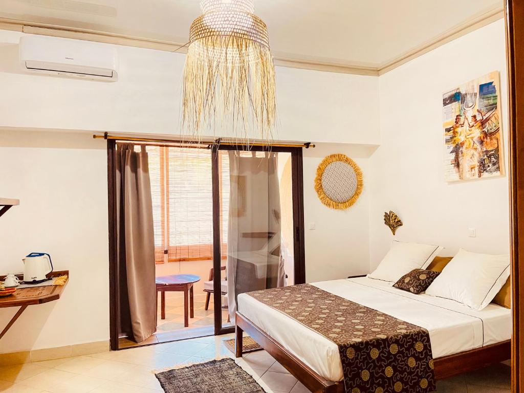 Un dormitorio con una cama y una lámpara de araña. en LE NOUVEL EDEN, en Toliara