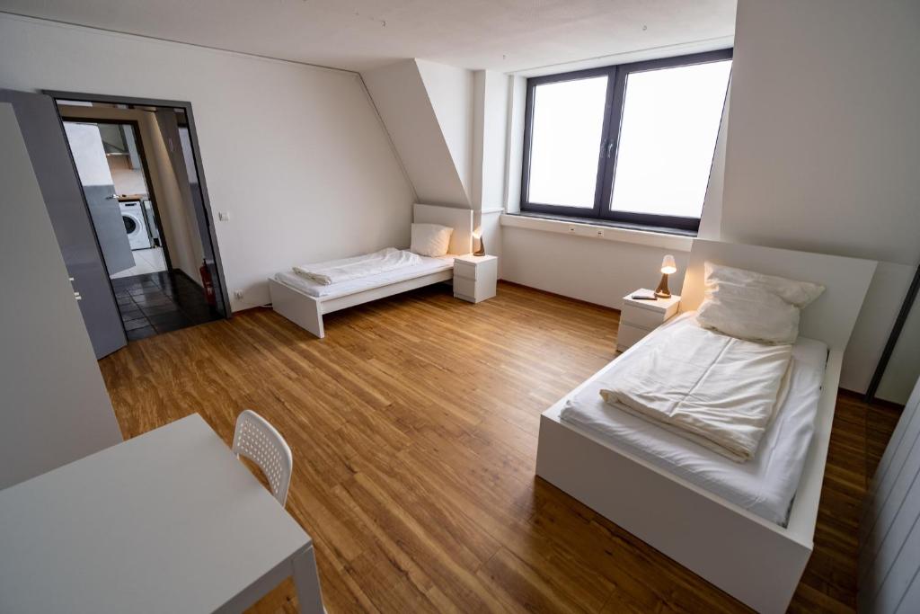 Habitación blanca pequeña con cama y mesa en ATRIUM - großzügige Apartment RHEINHORST RECHTS, en Ludwigshafen am Rhein