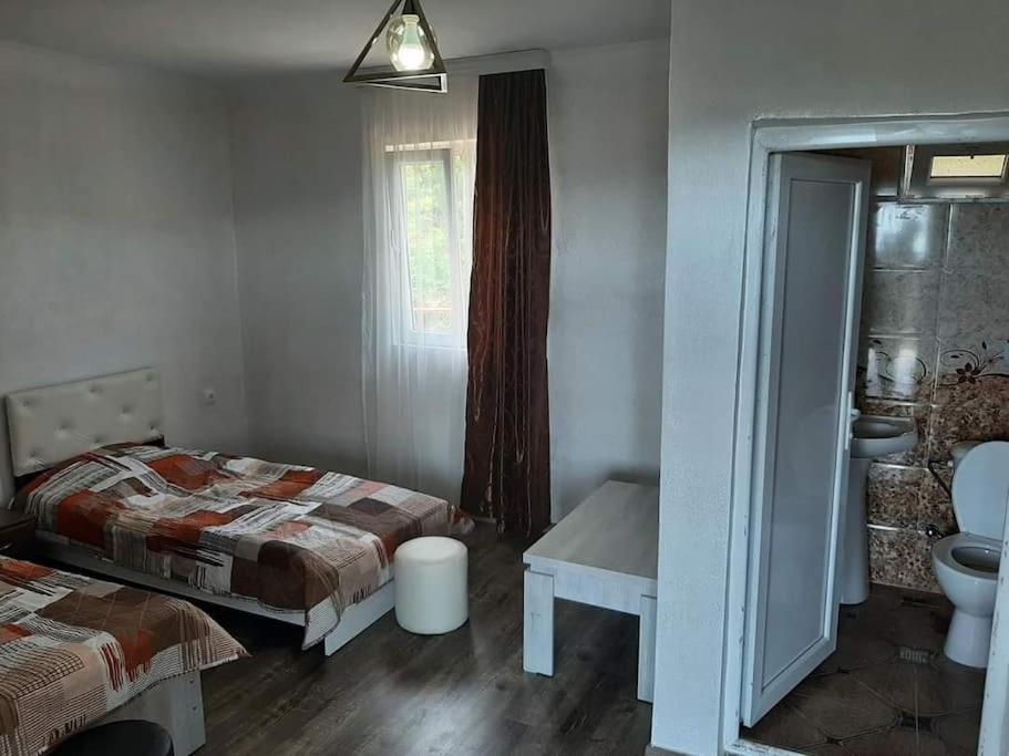 a bedroom with two beds and a sink and a window at ლამაზი სახლი და სასიამოვნო გარემო სტუმრებისთვის in Batumi