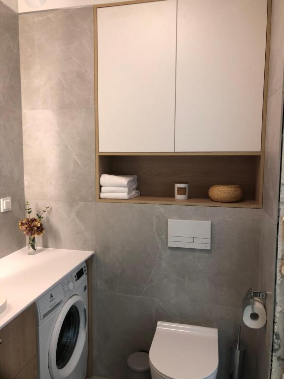 ein Badezimmer mit einem WC und einer Waschmaschine in der Unterkunft Black Pearl DeLuxe Apartments City View in Stettin